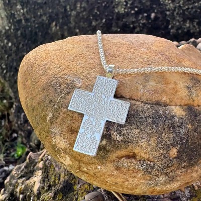 Cruz del Padre Nuestro mostrada sobre una piedra.