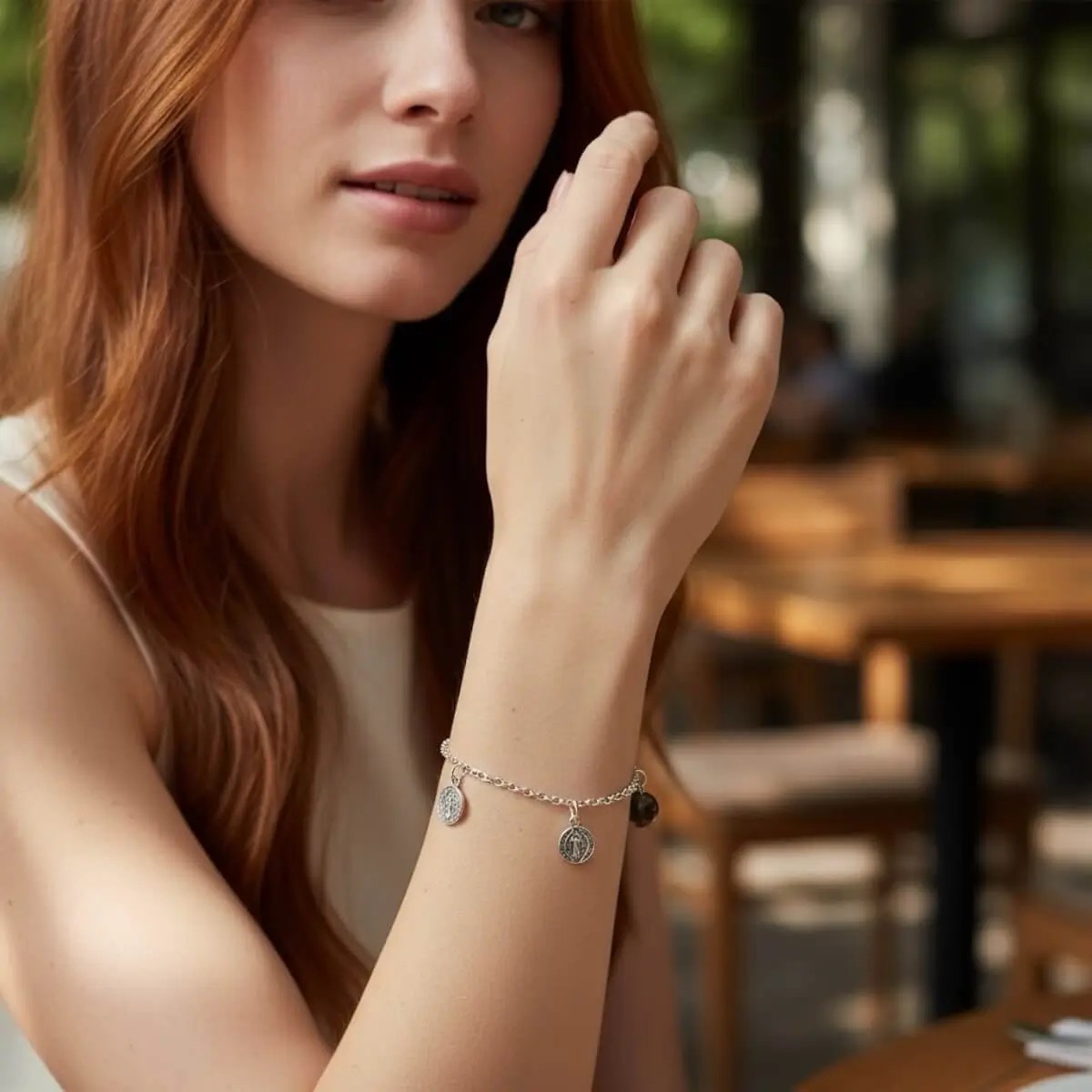 Modelo luciendo pulsera de san benito, vista frontal enfocando a la pulsera.
